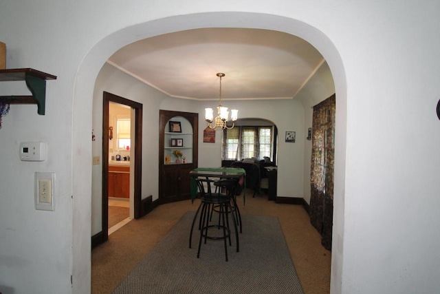 dining area with dark colored carpet and a chandelier