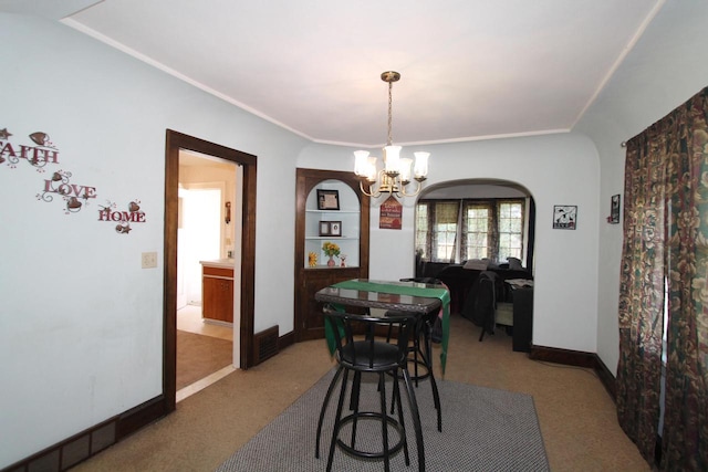 dining space with an inviting chandelier and light colored carpet