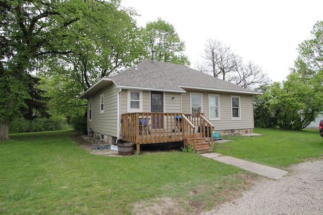 view of front facade featuring a front yard and a wooden deck