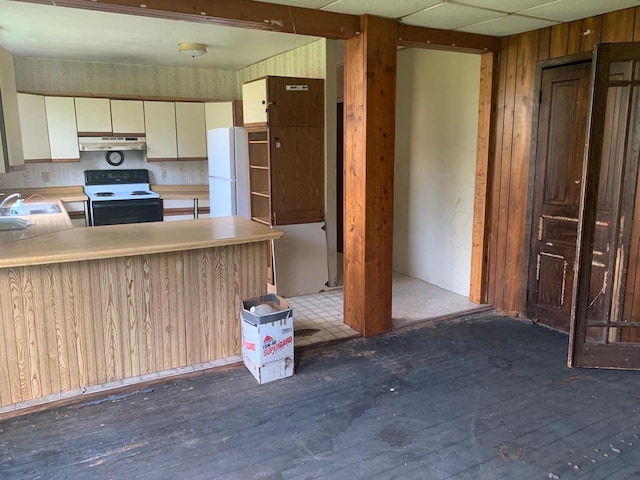 kitchen with wood walls, dark wood-type flooring, white cabinets, kitchen peninsula, and white appliances