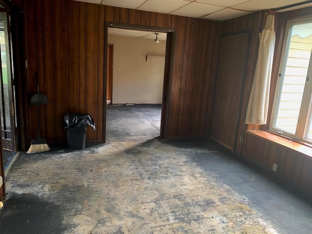 spare room featuring wood walls and a paneled ceiling