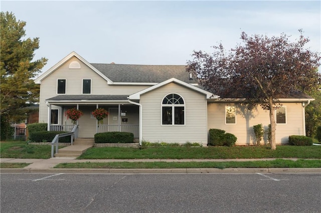 view of front facade featuring covered porch and a front lawn