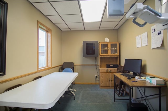 office featuring dark carpet, a drop ceiling, and a wealth of natural light