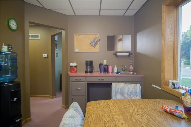 carpeted bedroom with a drop ceiling and sink