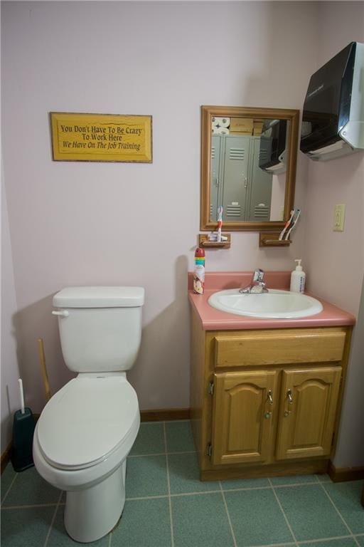 bathroom featuring tile flooring, toilet, and vanity