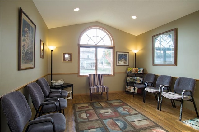 living room featuring lofted ceiling and hardwood / wood-style flooring