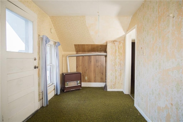 hall featuring lofted ceiling and dark colored carpet