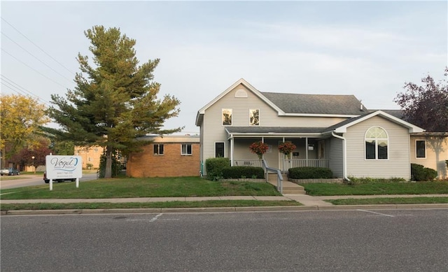 view of front of home with covered porch and a front lawn