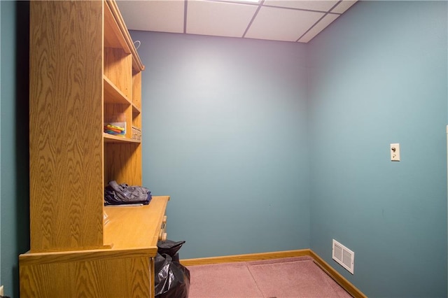 carpeted office space with a paneled ceiling