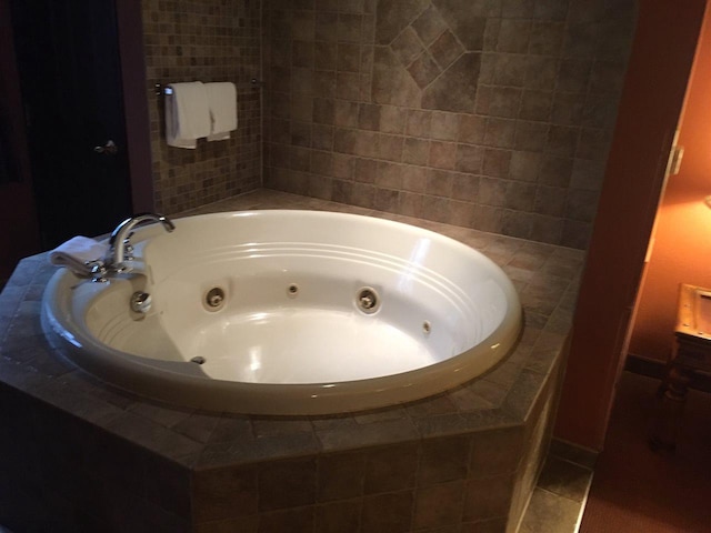 bathroom featuring tile flooring and tiled tub