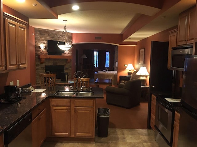 kitchen with stainless steel appliances, a fireplace, light tile floors, sink, and kitchen peninsula