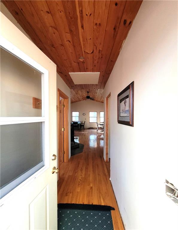 hallway with wooden ceiling, wood-type flooring, and vaulted ceiling