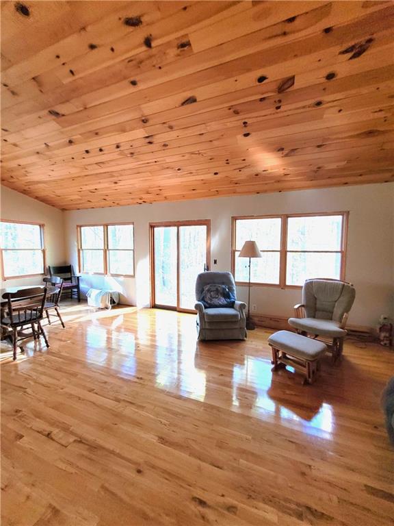 living room with light hardwood / wood-style floors, vaulted ceiling, and wood ceiling