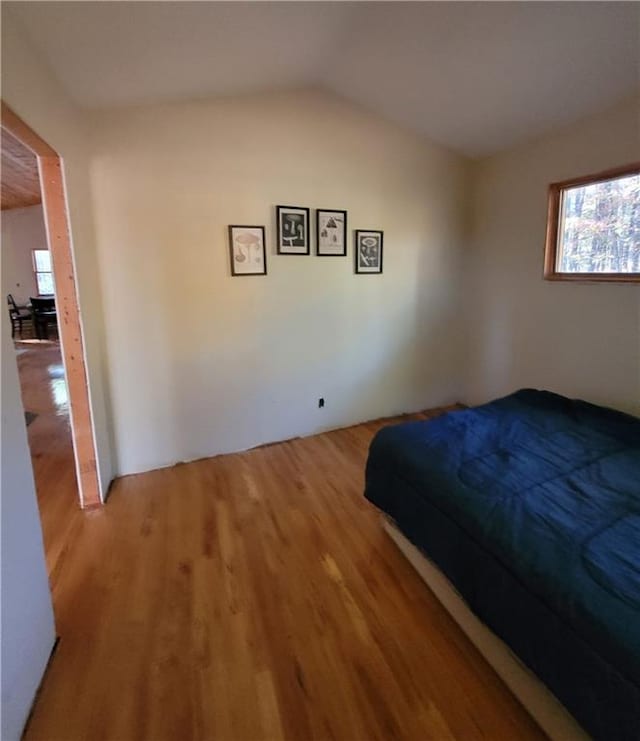 bedroom with wood-type flooring and lofted ceiling