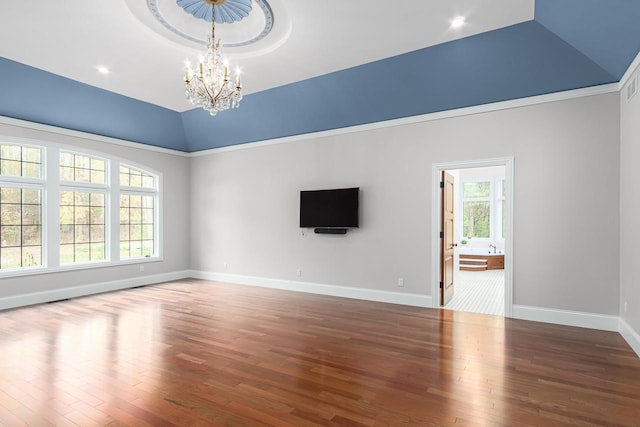 empty room featuring dark hardwood / wood-style floors, a notable chandelier, and vaulted ceiling