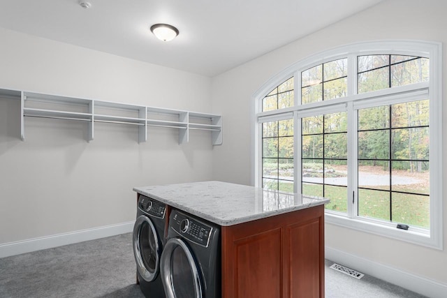 clothes washing area with light carpet, cabinets, and washing machine and clothes dryer