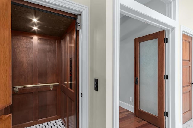 interior space with elevator and dark hardwood / wood-style flooring