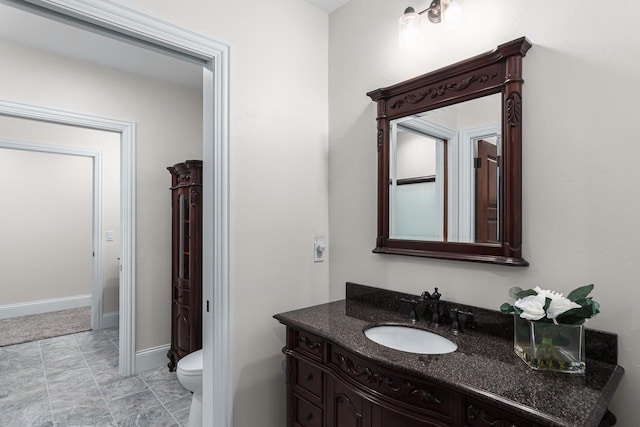 bathroom with toilet, tile flooring, and vanity