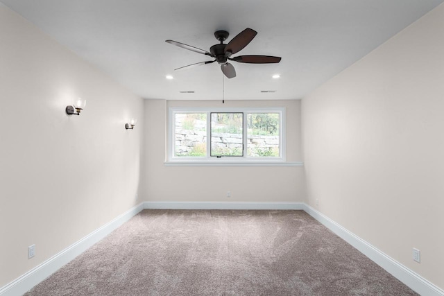 spare room with ceiling fan and light carpet