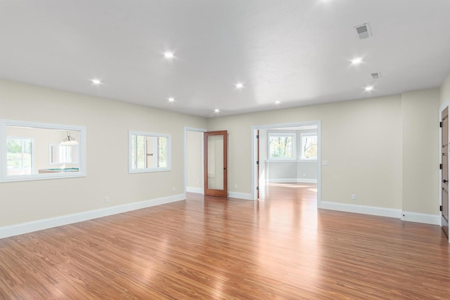 empty room with plenty of natural light and light hardwood / wood-style floors