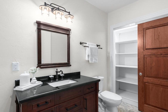 bathroom featuring toilet, tile flooring, and vanity