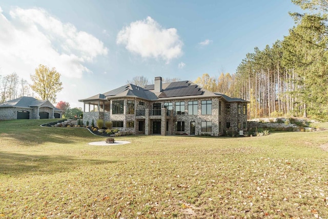 rear view of house with solar panels and a yard