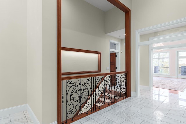 hallway with light tile flooring and a towering ceiling