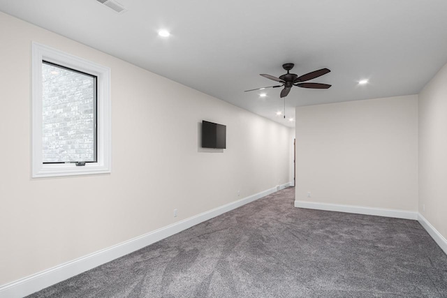 unfurnished room featuring ceiling fan and dark carpet