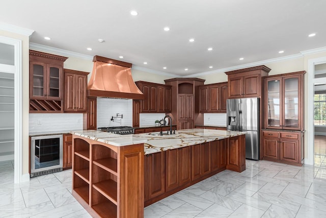 kitchen with light stone counters, a center island with sink, wine cooler, custom range hood, and stainless steel refrigerator with ice dispenser