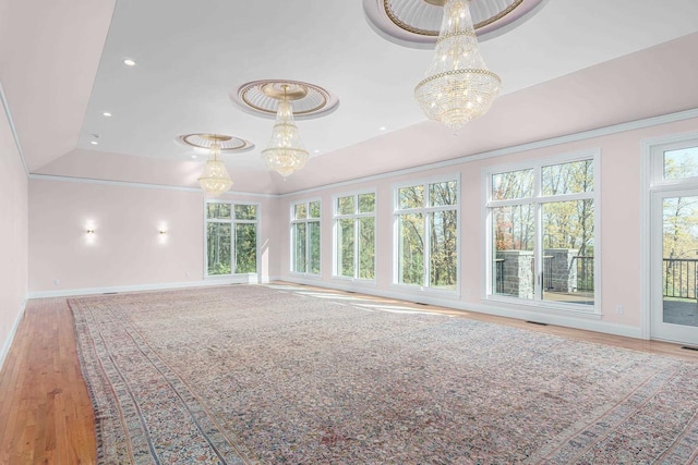 empty room featuring vaulted ceiling, light hardwood / wood-style floors, and an inviting chandelier