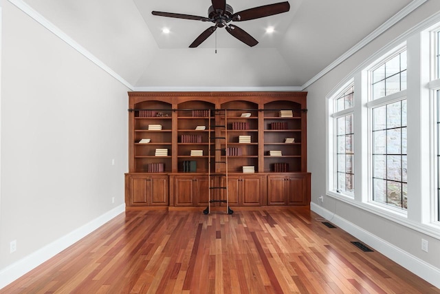 unfurnished office with ceiling fan, crown molding, light wood-type flooring, and vaulted ceiling