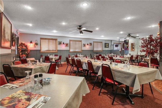 carpeted dining room with ceiling fan and a textured ceiling