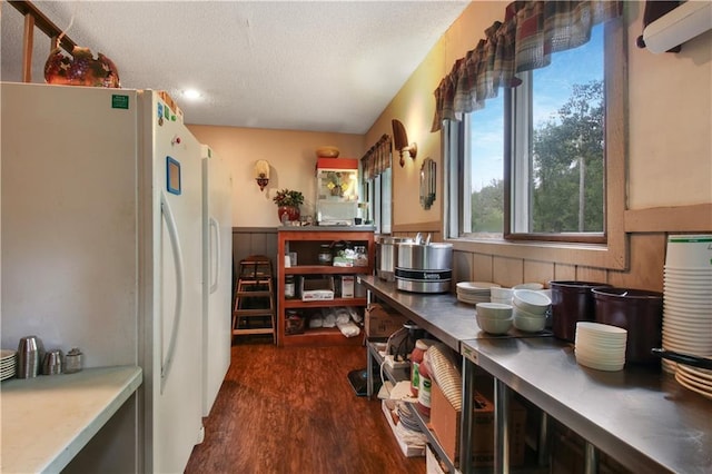 kitchen with a textured ceiling, dark wood-type flooring, and white refrigerator