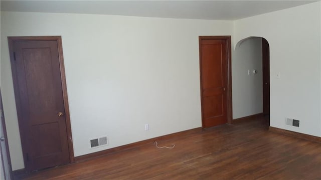 unfurnished room with dark wood-type flooring