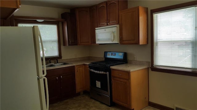 kitchen featuring white appliances, tile floors, and sink