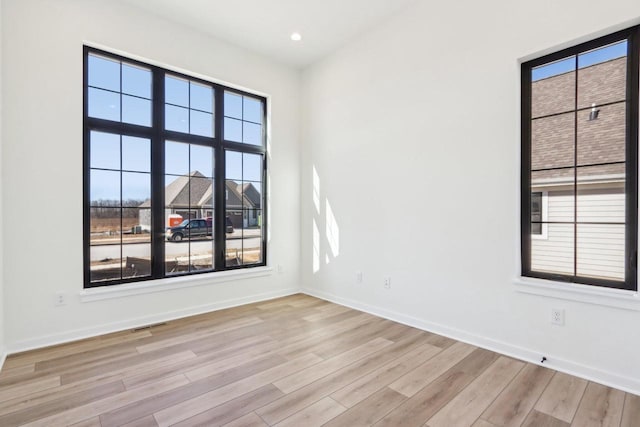 unfurnished room featuring recessed lighting, light wood-type flooring, and baseboards