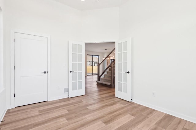 unfurnished room featuring visible vents, french doors, light wood-type flooring, and baseboards