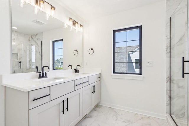 bathroom featuring marble finish floor, a healthy amount of sunlight, and a sink