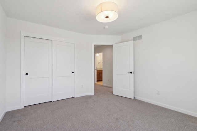 unfurnished bedroom with visible vents, baseboards, light colored carpet, and a closet