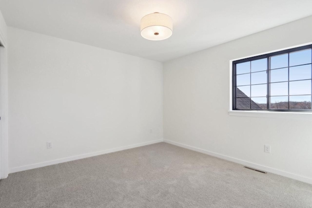 carpeted empty room with visible vents and baseboards