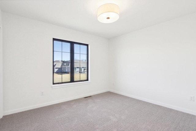 empty room with baseboards and carpet