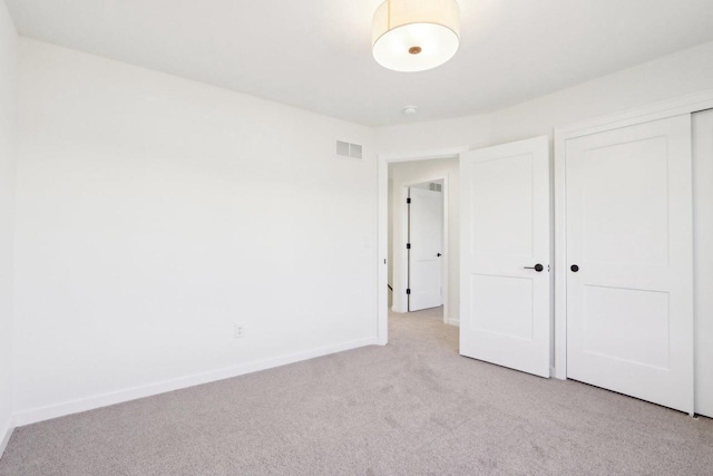 unfurnished bedroom with a closet, visible vents, baseboards, and carpet