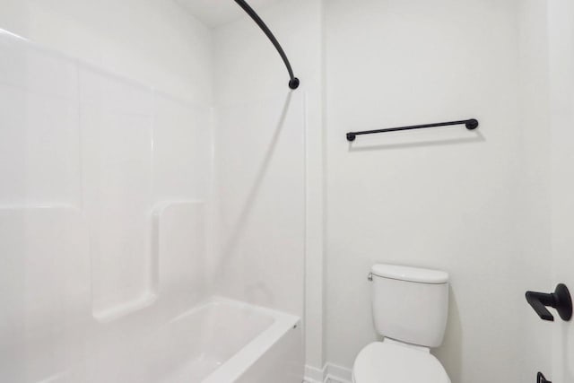 bathroom with toilet, shower / bath combination, and baseboards