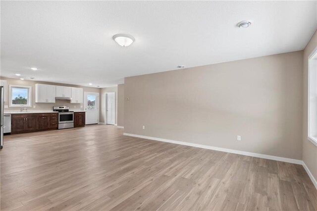 unfurnished living room featuring light hardwood / wood-style floors and sink