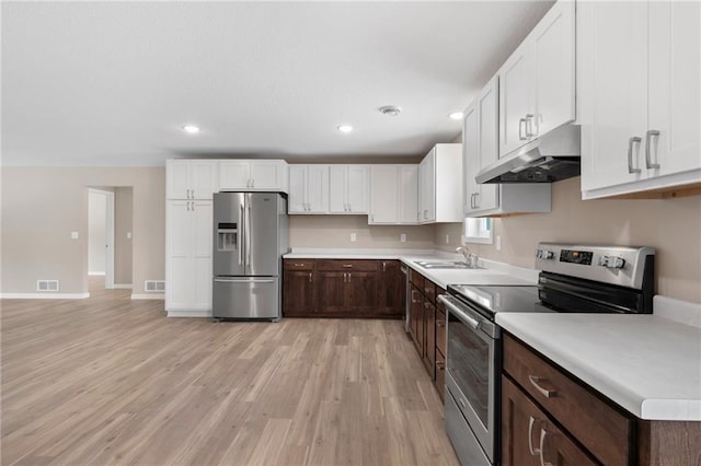 kitchen with white cabinetry, dark brown cabinets, stainless steel appliances, and sink