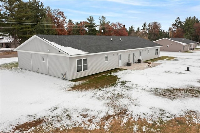 snow covered house featuring central AC unit