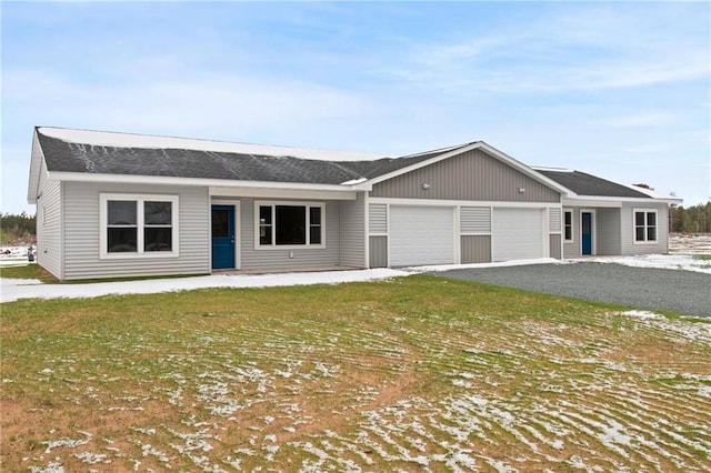 ranch-style house featuring a front yard and a garage