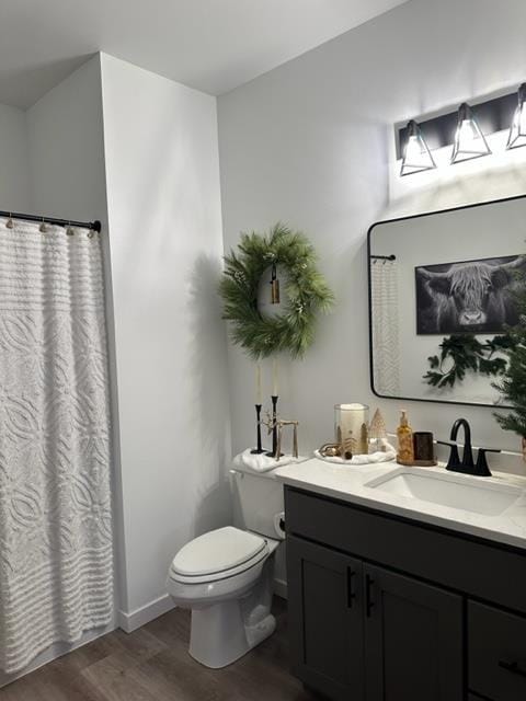 bathroom with toilet, vanity, and hardwood / wood-style flooring