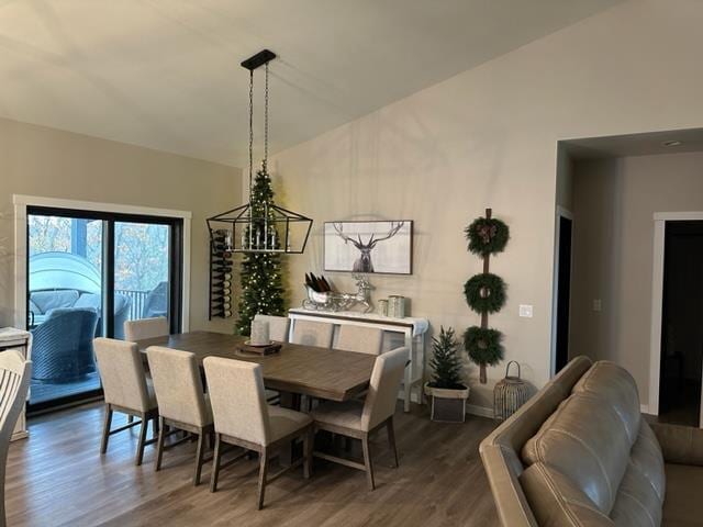 dining space with dark hardwood / wood-style flooring and a chandelier