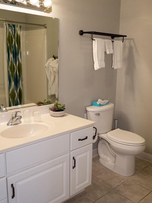 bathroom with toilet, vanity, tile patterned floors, and curtained shower